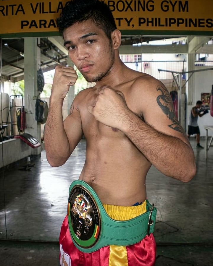 Dennis Tubieron in a boxing gym with his WBC International belt